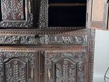 a wooden cabinet with a door open on a tile floor