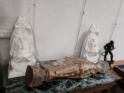 une statue représentant un homme posée sur une table, à côté d'une autre statue représentant un homme