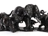 a statue of a herd of elephants on a white surface