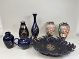 many vases and a bowl sitting on a table