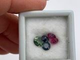 someone is holding a small square box with three gems in it