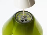 a green lamp that has a white shade on top of it