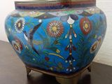 a blue vase sitting on a wooden table with a white wall in the background