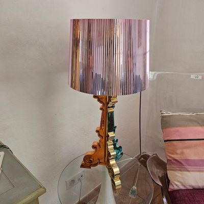 une lampe posée sur une table à côté d'un lit