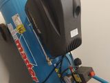 a blue air compressor attached to a wall with a hose attached to it