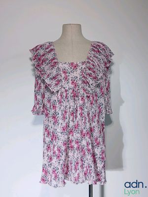 Haut à fleurs rose et blanc avec des volants, présenté sur un mannequin