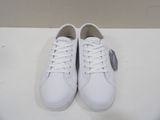 a pair of white sneakers on a white surface