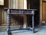 une table en bois au plateau sculpté, placée au milieu d'une pièce
