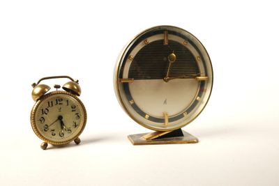 deux horloges placées l'une à côté de l'autre sur une surface blanche