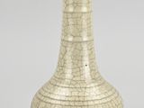 un vieux vase blanc à la peinture écaillée posé sur une table