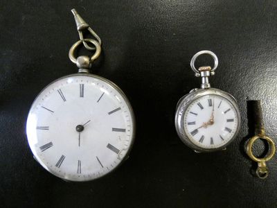 deux horloges et une clé posées sur une table