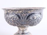 a silver bowl that is sitting on a white surface
