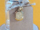 a small jar with a tag on it sitting on a piece of wood