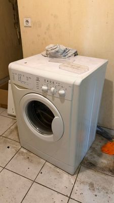 une machine à laver posée dans un coin de la pièce