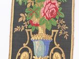 a picture of a wall hanging with a vase of flowers