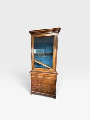 une vieille vitrine en bois avec une porte vitrée sur le dessus
