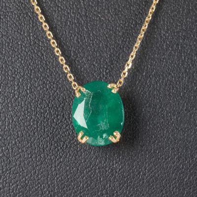 Gros plan sur un collier orné d'une pierre verte