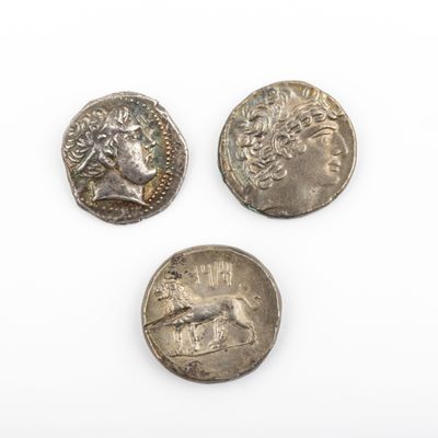 trois pièces romaines, dont l'une porte une tête et l'autre un visage