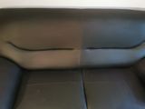 a black leather couch that is in the corner of a room