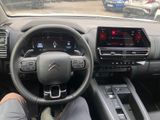 a man sitting in the driver ' s seat of a car