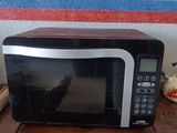 un micro-ondes posé sur une table, avec une boîte dessus
