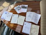 many papers on the table next to a car