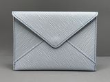 une enveloppe blanche ornée d'une couture bleue