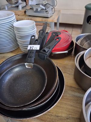 many pans and pans sitting on a table in a kitchen