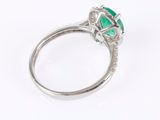 a close up of a ring with a green stone and diamonds