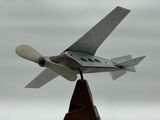 une petite maquette d'avion de chasse posée sur un socle en bois