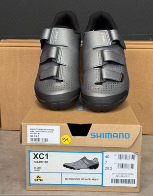 deux paires de chaussures Shimano dans une boîte posée sur une table