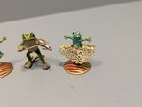 four figurines of frogs that are on top of a table