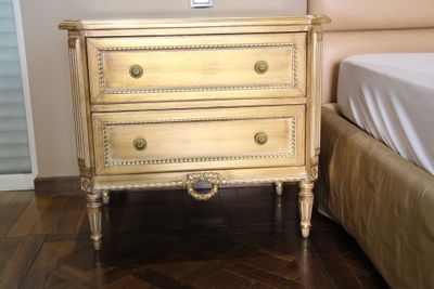 une image représentant une chambre à coucher, avec un gros plan sur la commode