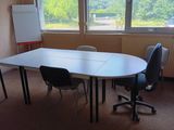 une table avec des chaises et un tableau blanc dans une pièce