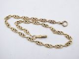 a close up of a gold chain on a white surface