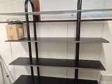 a black shelf with shelves on it in a room