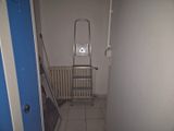 une échelle dans le couloir d'une maison, sur laquelle est accrochée une pancarte