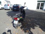 a motor scooter parked in a parking lot next to a building