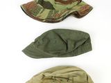 three hats are lined up on top of each other on a white surface