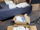a box full of white shirts on the floor