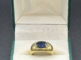 une bague en or jaune sertie d'un saphir bleu