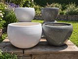 trois bols blancs et gris posés sur un plateau en bois