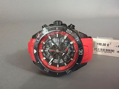 La montre est rouge et noire et porte une étiquette.