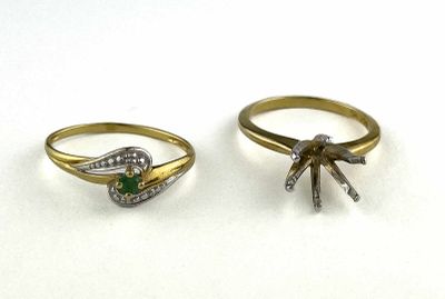 two gold rings with diamonds and emerald stones on them