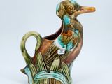 a ceramic duck that is sitting on a planter