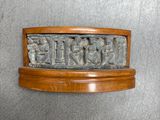 une image représentant une plaque en bois ornée d'un motif sculpté