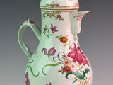 a white vase with a pink and green floral design on it