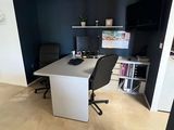 a white desk with a black chair in the corner of the room