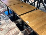 two wooden tables with metal legs in a room