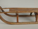 une vieille luge en bois surmontée d'une autre luge